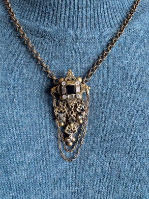 victorian necklace with intricate design on a blue textured background