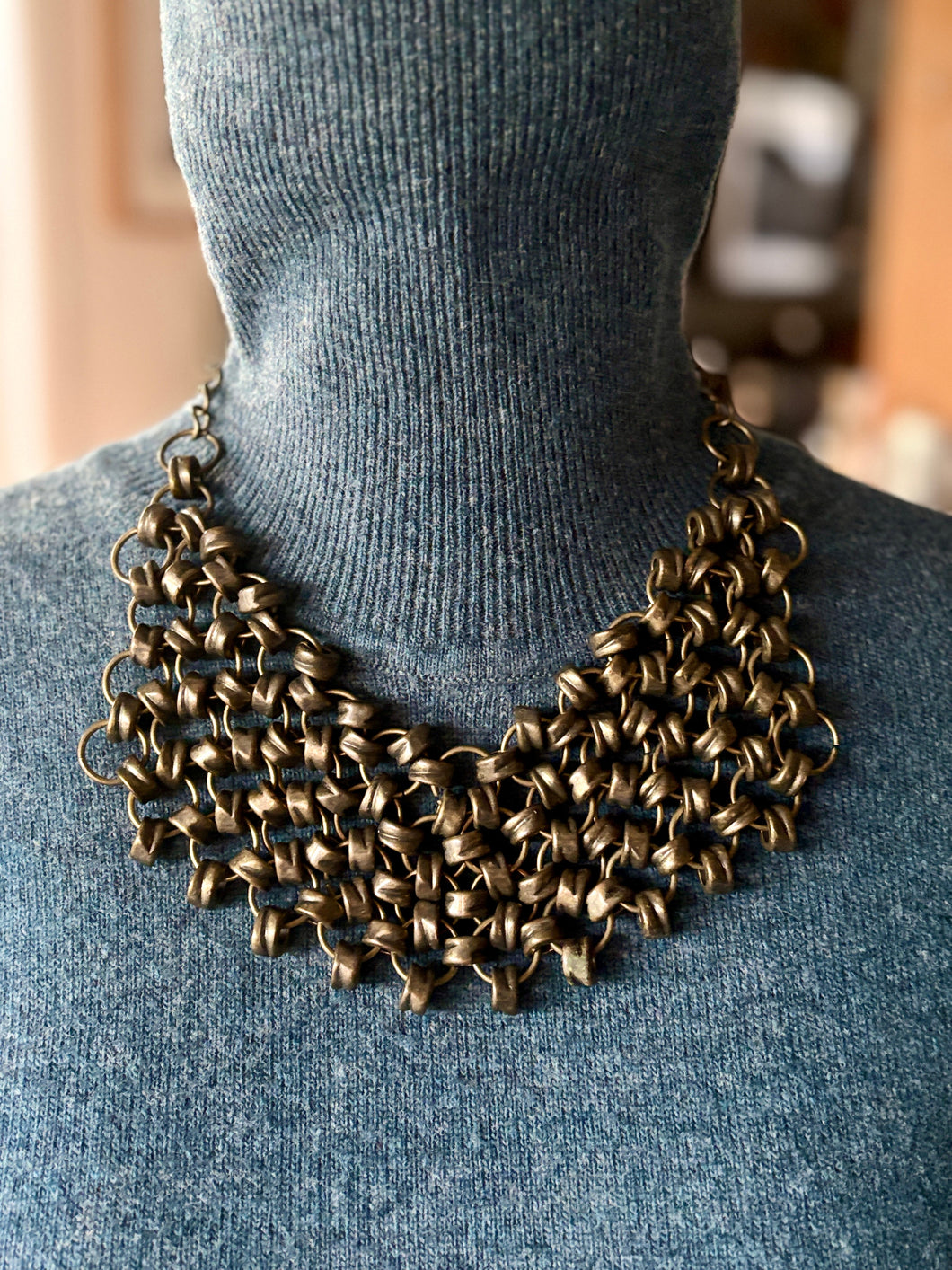 Bronze Fan style chain necklace on a person wearing a blue sweater