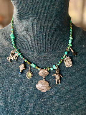sterling Necklace with charms on a mannequin wearing a dark green sweater